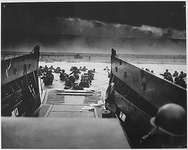 American soldiers disembark from a landing craft on D-Day, 1944.