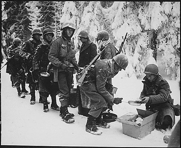 Cold, snowy American GIs wait for chow during the Battle of the Bulge.