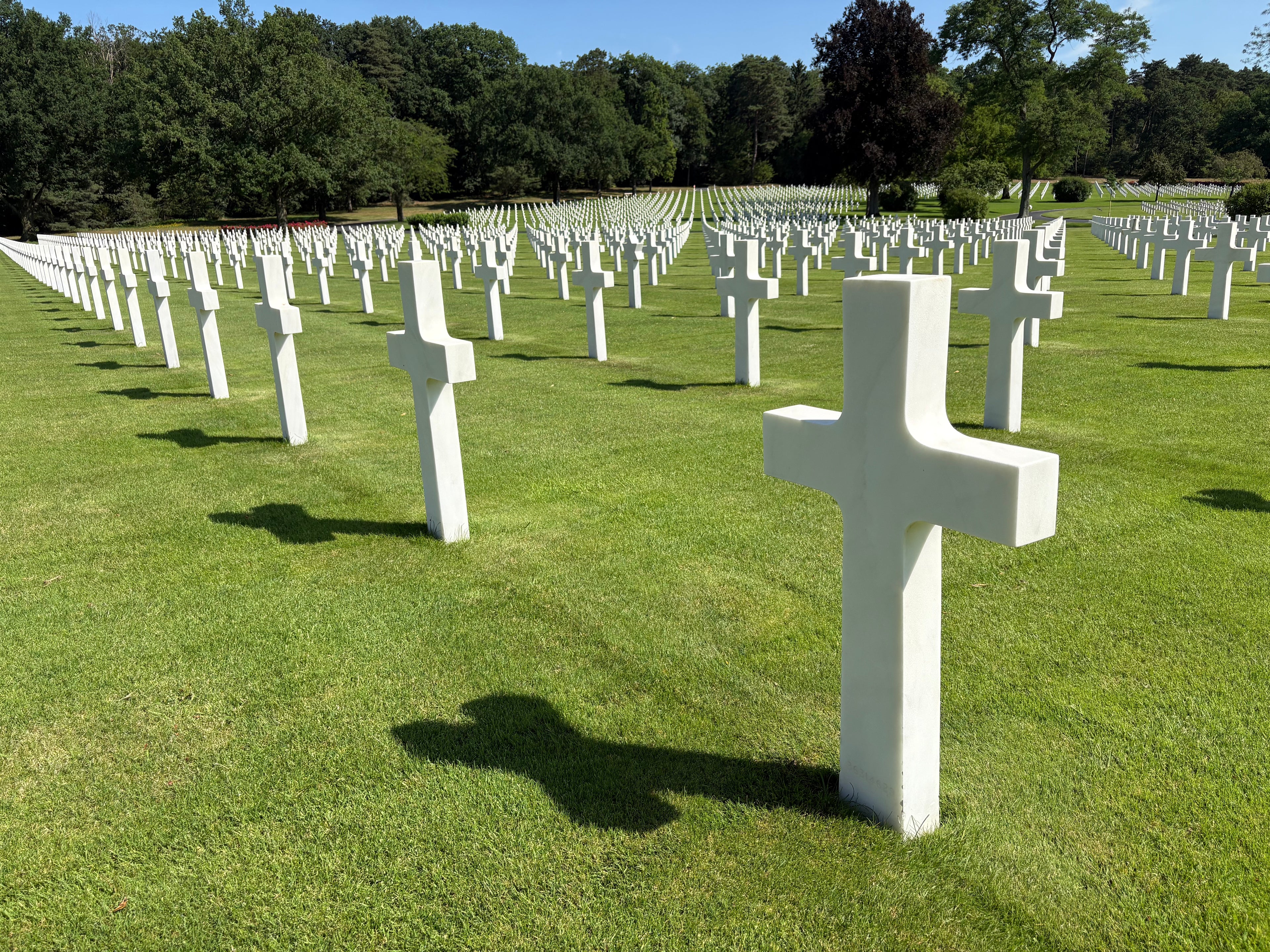 Wartime cemetery with rows of white crosses on a grassy field